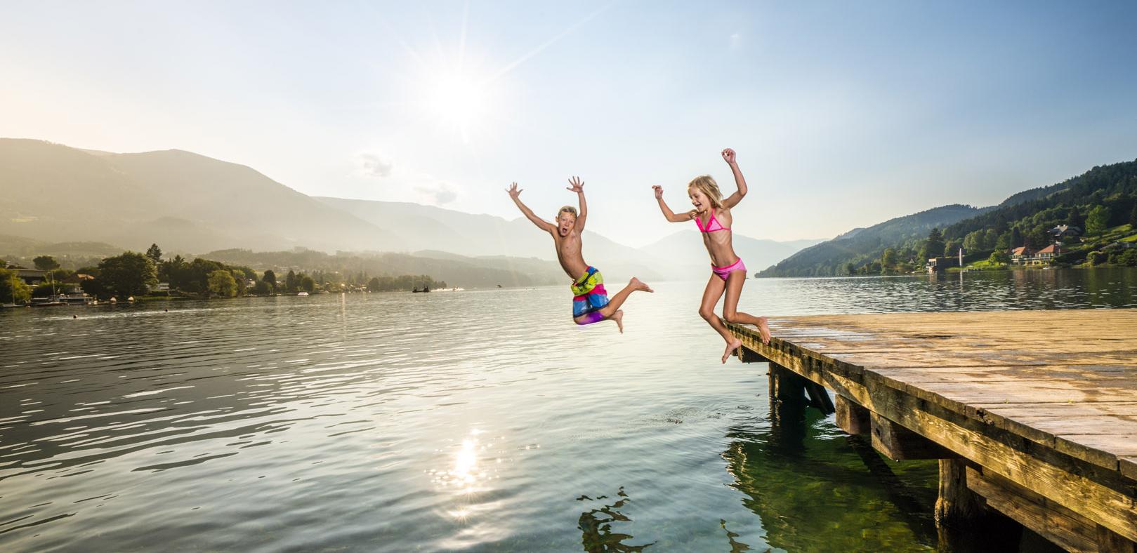 Kinder springen in See vom Steg aus Kinder Seesprung