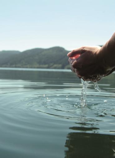 Zwei Hände schöpfen Wasser aus dem See Seeberührung